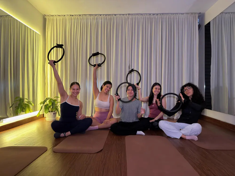 Alumnas de Pilates Mat levantando aros en el estudio